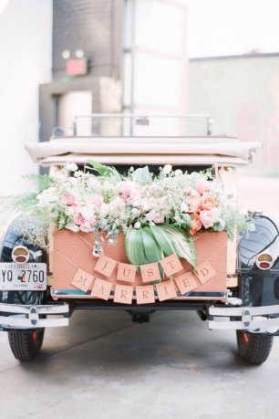 Ретро-автомобиль, украшенный цветами, с надписью "just married"