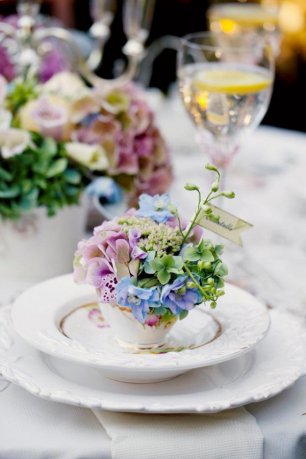 Оформление стола: цветы в чашках с банкетными карточками