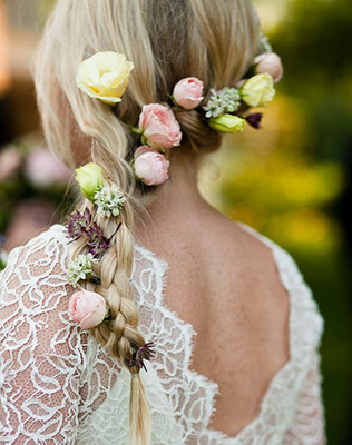 Прическа невесты: простая коса, украшенная разноцветными розами