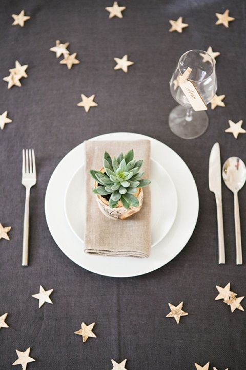 Интересное оформление стола: скатерть со "звездами" и растение на тарелке каждого гостя
