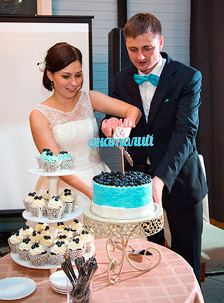 бело-голубая свадьба, жених и невеста режут торт
