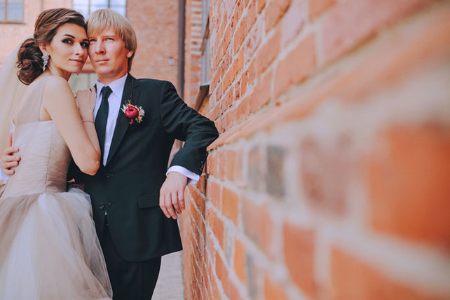 Дыхание бохо в цвете марсала, жених и невеста у кирпичной стены