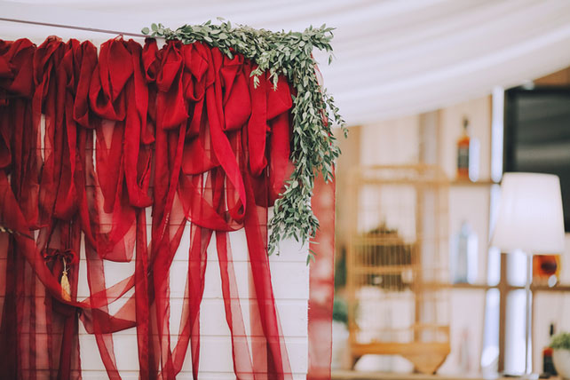 Дыхание бохо в цвете марсала, красные ленты в декоре 