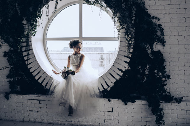 Элегантная свадьба, жених и невеста у круглого окна