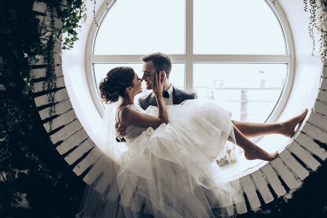 Элегантная свадьба, жених и невеста у круглого окна