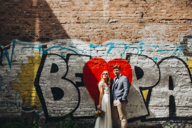 Фуршетная свадьба, жених и невеста у стены с граффити