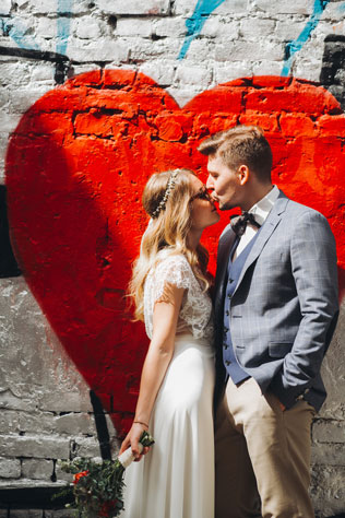 Фуршетная свадьба, жених и невеста у стены с граффити