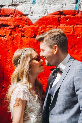 Фуршетная свадьба, жених и невеста у стены с граффити