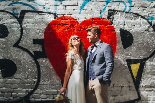 Фуршетная свадьба, жених и невеста у стены с граффити
