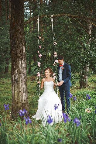 Милая летняя свадьба, жених и невеста на качелях