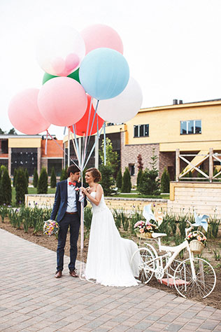 Милая летняя свадьба, жених и невеста с большими шарами