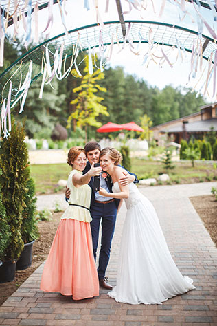 Милая летняя свадьба, жених и невеста с гостями