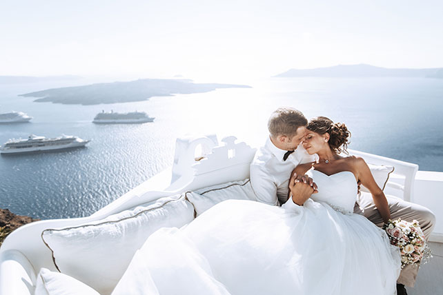 На краю света, жених и невеста на диване с видом на море