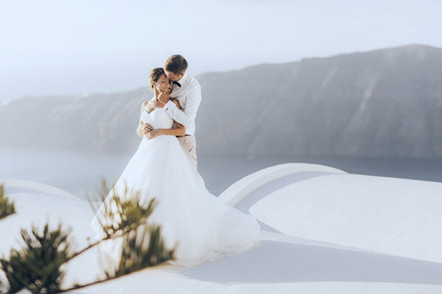 На краю света, жених и невеста на фоне гор и моря