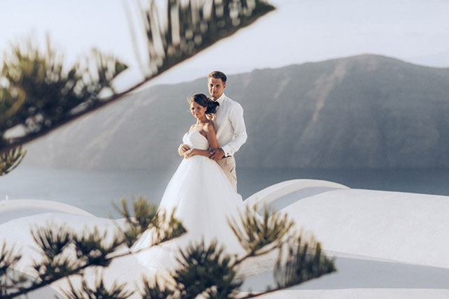 На краю света, жених и невеста на фоне гор и моря