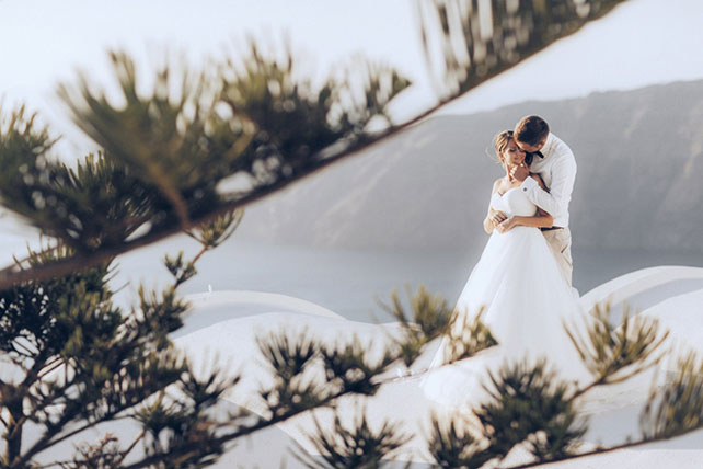 На краю света, жених и невеста на фоне гор и моря