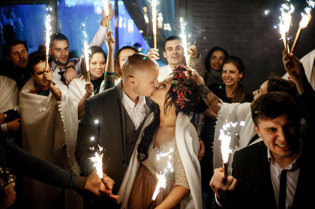 Окрыленные любовью, жених и невеста с гостями и бентгальскими огнями