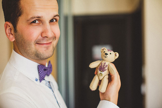 Очарование Прованса, лавандовая свадьба, жених держит в руках плюшевого медвежонка