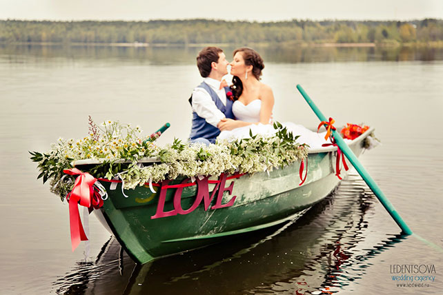 Красно-белая сердечная свадьба Дмитрия и Ольги, жених и невеста в лодке, украшенной цветами