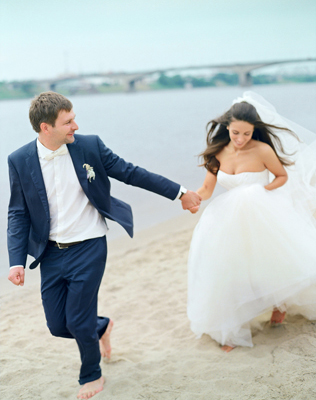 Жених и невеста бегут по берегу