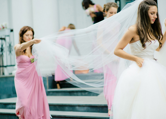 Подружка держит фату невесты