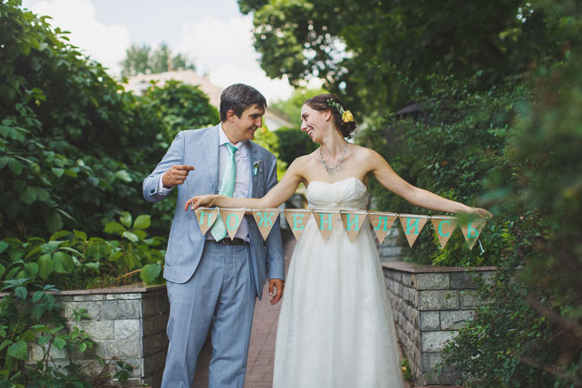 Мятная свадьба с городской фотосессией, жених и невеста с флажками