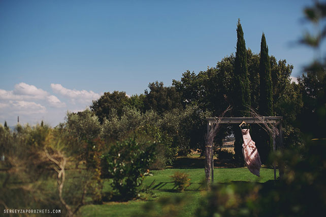 Солнечная свадьба в Тоскане, платье невесты висит на арке