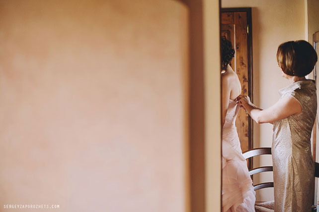 Солнечная свадьба в Тоскане, мама помогает невесте надеть платье