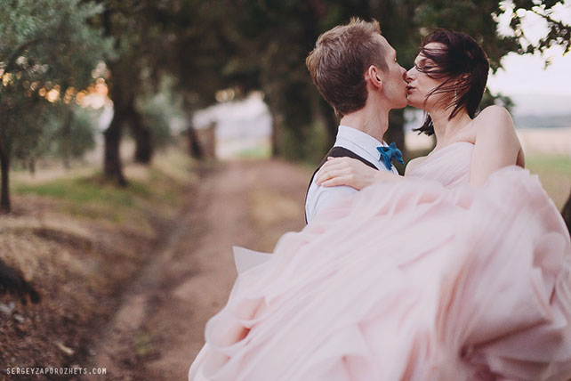 Солнечная свадьба в Тоскане, жених держит невесту на руках