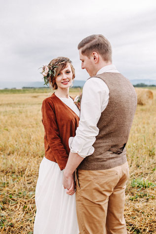 Стильная рустикальная свадьба, жених и невеста на поле со снопами