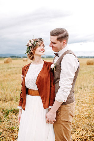 Стильная рустикальная свадьба, жених и невеста на поле со снопами