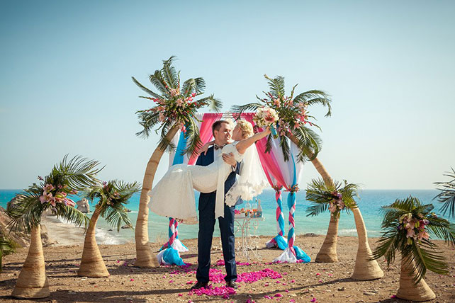 Свадьба на Кипре, жених держит невесты на руках