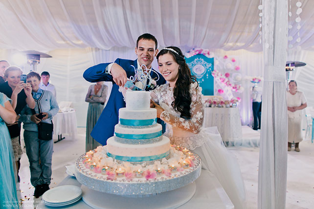 свадьба в нежных тонах, розовый и бирюзовый, церемония, жених и невеста режут торт