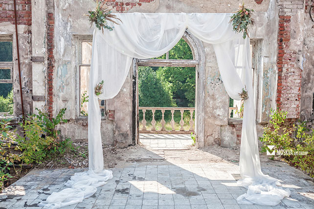 свадьба в разрушенной усадьбе, свадебная арка, украшенная тканью и цветами