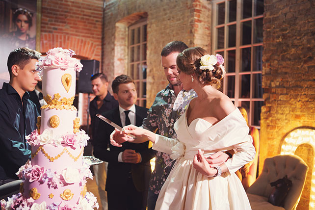 Ужин после венчания в стиле Dolce&Gabbana, жених и невеста разрезают свадебный торт