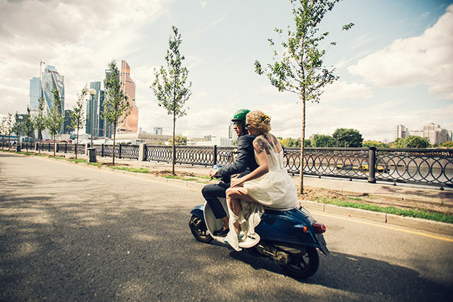 Винтажная свадьба в стиле путешествия, жених и невеста едут на мопеде по городу