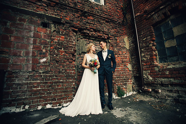 Винтажная свадьба в стиле путешествия, возле кирпичной стены