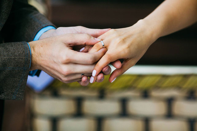 Воздушная свадьба, жених надевает кольцо на палец невесты 