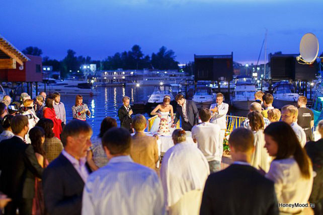 зелено-оранжевая свадьба, жених и невеста режут торт