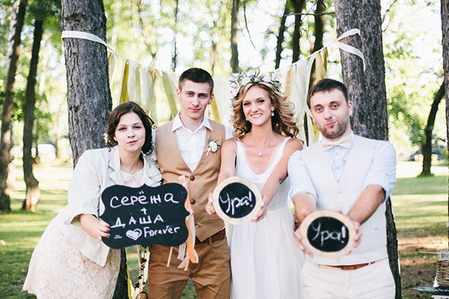 задорная рустикальная свадьба, жених и невеста с гостями