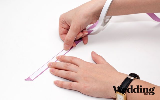 как сделать бонбоньерку-ключик, наклеить полоску двухстороннего скотча на атласную ленту