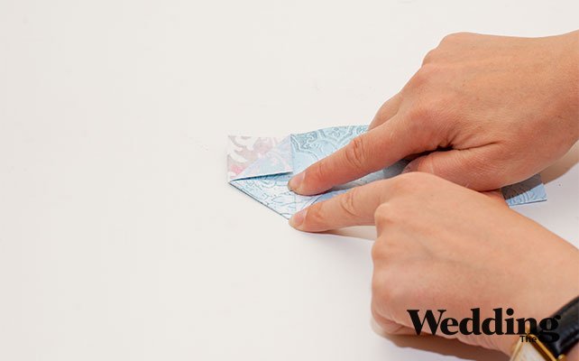 половинку развернуть и верхушки сложить в треугольники с двух сторон